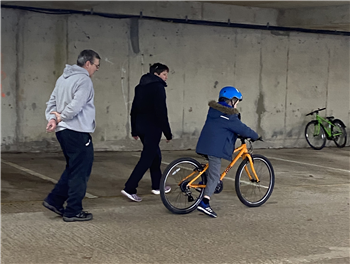 child on bike with 2 instructors
