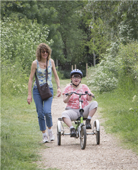 girl on tricycle with adult
